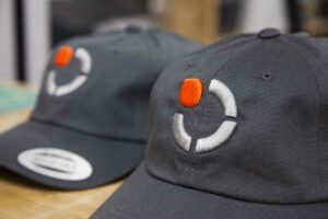 grey baseball cap with a logo embroidered on it