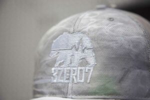 grey baseball cap with a logo embroidered onto it