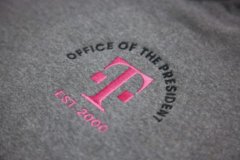 a grey polo with the t-mobile logo embroidered on it
