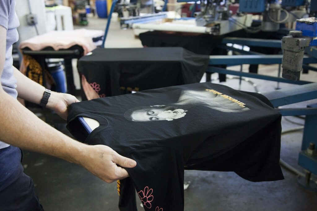 a black long sleeve shirt on a screen printer