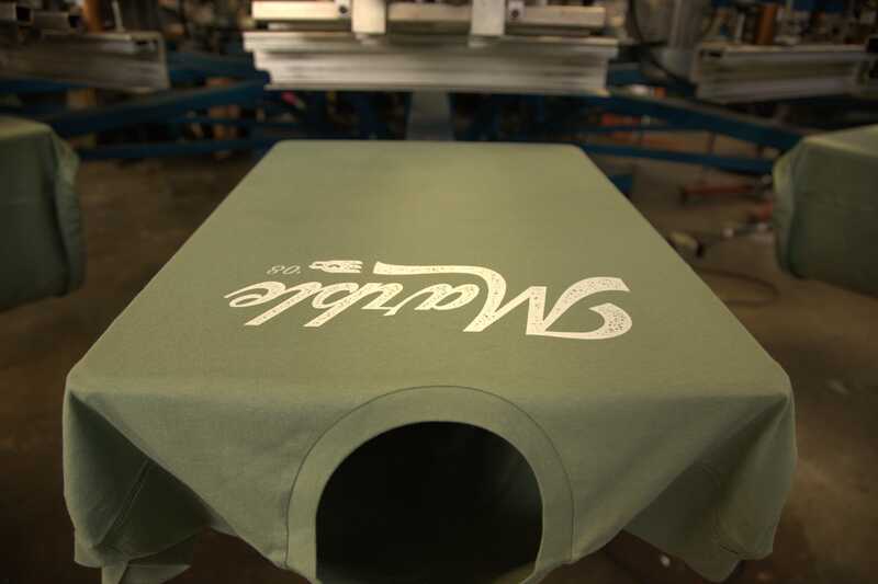 green t-shirt on a screen printer with text