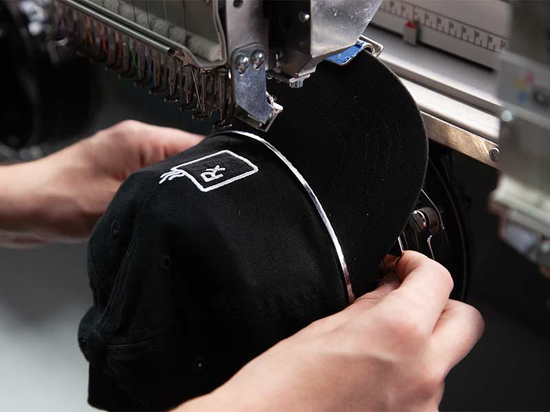 embroidery machine putting a logo on a hat