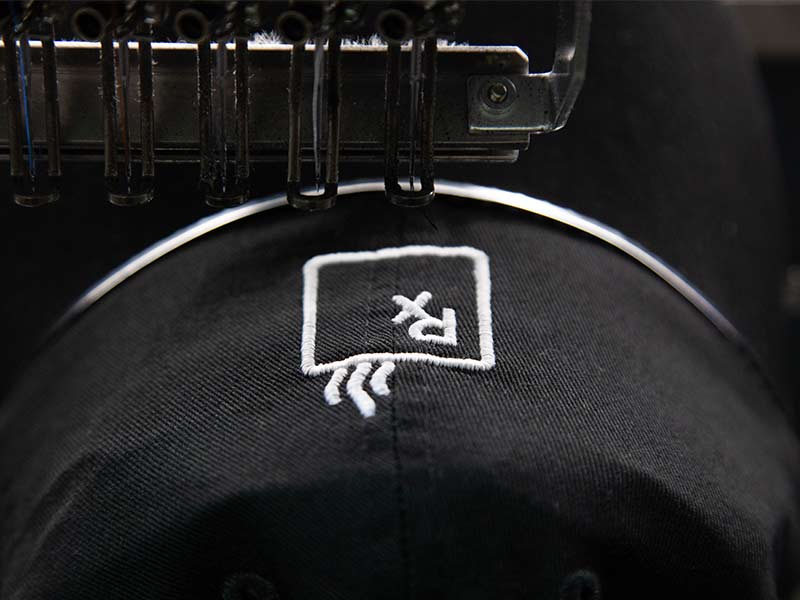 embroidery machine putting a logo on a hat