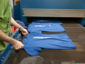 Blue t-shirts laid out in a row